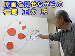 原画を見せながらの橿尾正次氏